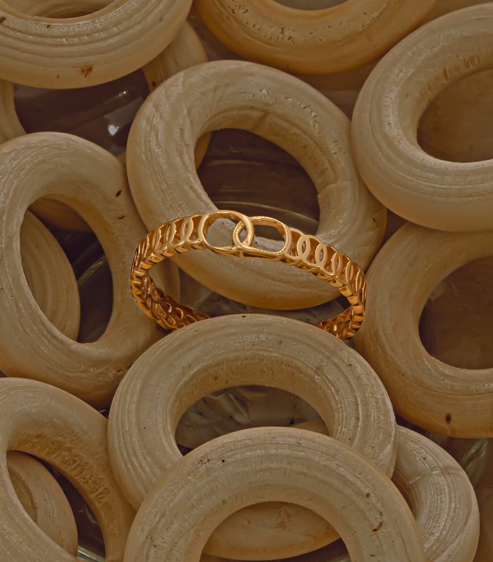 Polished gold ring with an openwork chain-inspired band design.