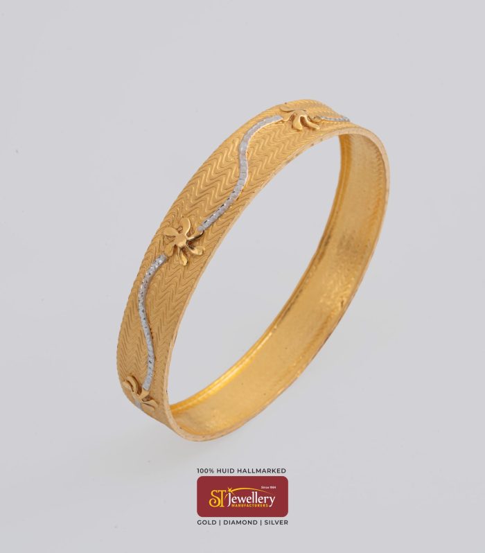 Elegant textured gold bangle with wave pattern and floral accents – premium gold jewellery by ST Jewellery Manufacturers Thrissur Kerala