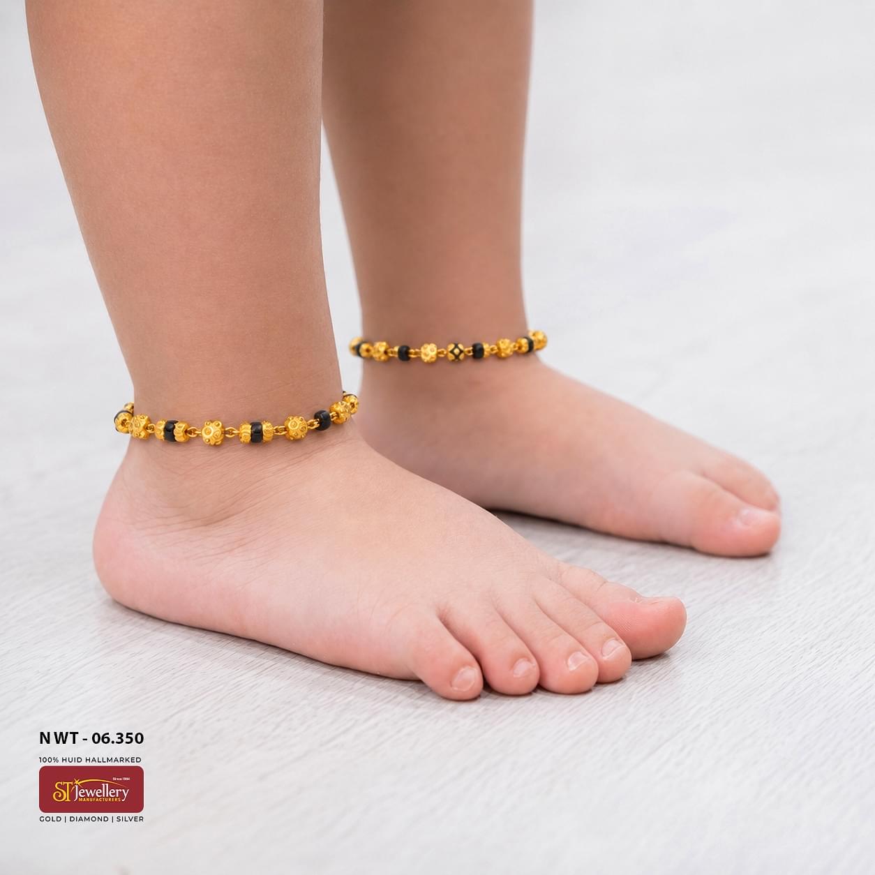 Traditional gold and black bead anklet for kids with floral gold bead accents, lightweight daily wear payal design.
