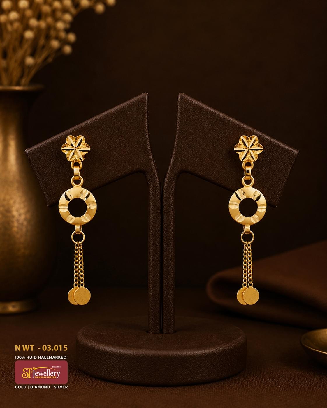 Elegant gold drop earrings featuring floral stud tops, circular textured ring motifs, and delicate chain tassels with disc charms for a modern and festive look.