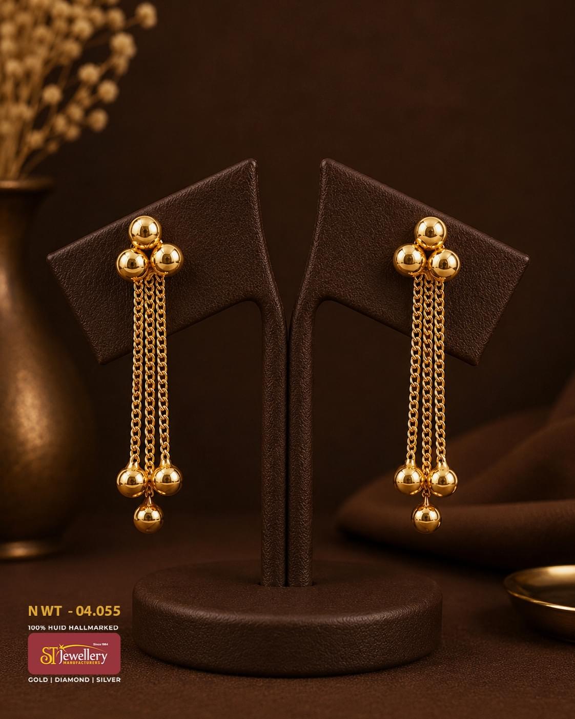 Elegant gold tassel drop earrings featuring triple polished gold ball studs with cascading chain tassels and dangling gold bead accents, perfect for festive and party wear.