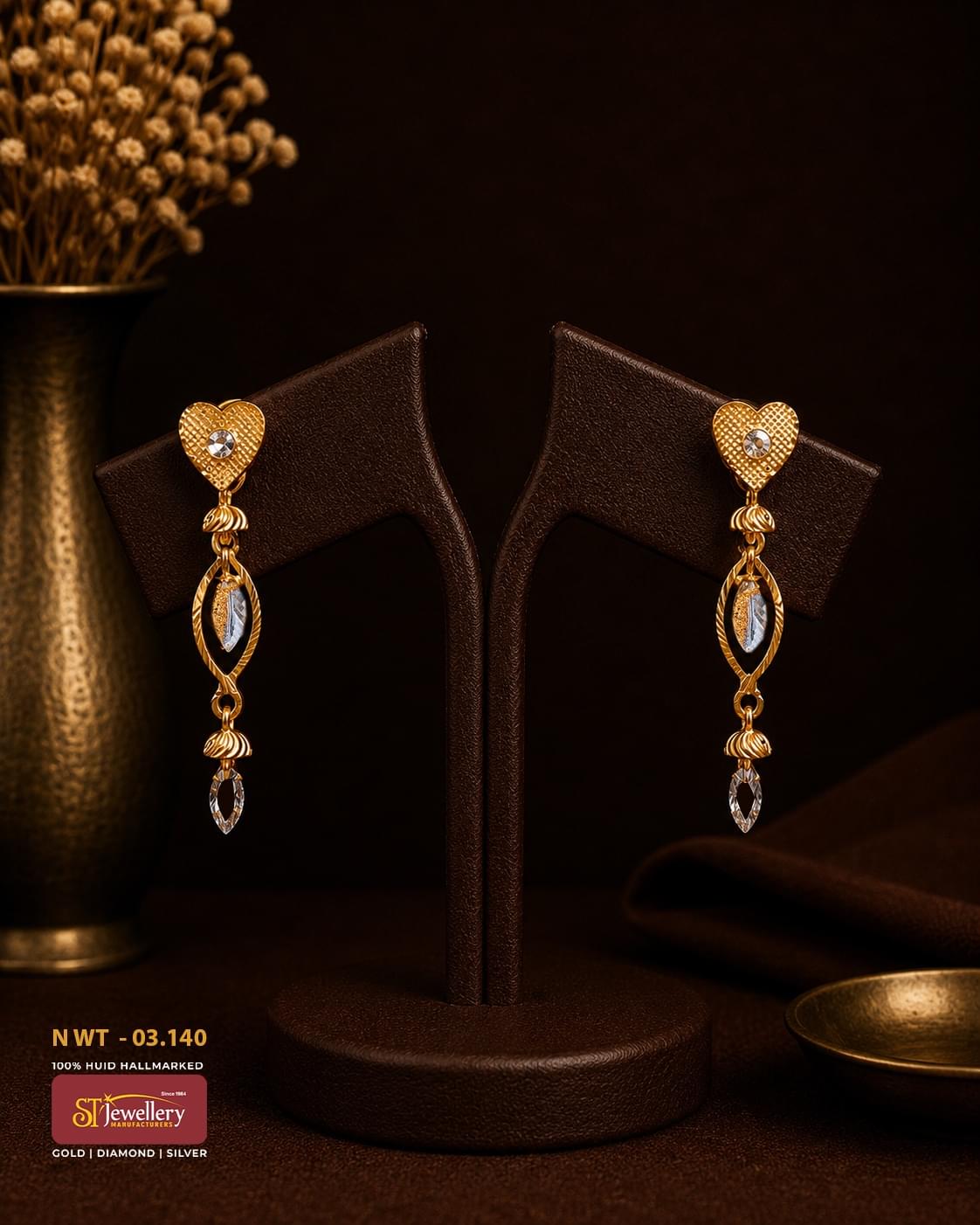 Elegant two-tone heart gold drop earrings featuring textured heart-shaped studs with sparkling stones, open marquise motifs with white gold accents, and delicate crystal drop pendants.
