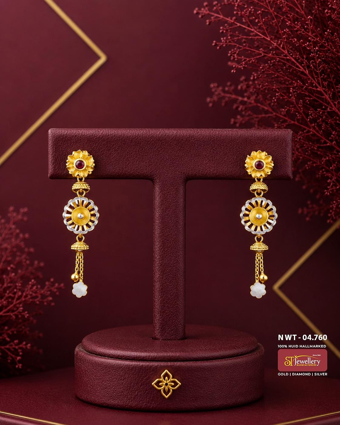 Elegant two-tone gold drop earrings featuring floral ruby-inspired studs, circular white enamel motifs, and delicate chain tassels with white flower charms, perfect for festive and traditional wear.