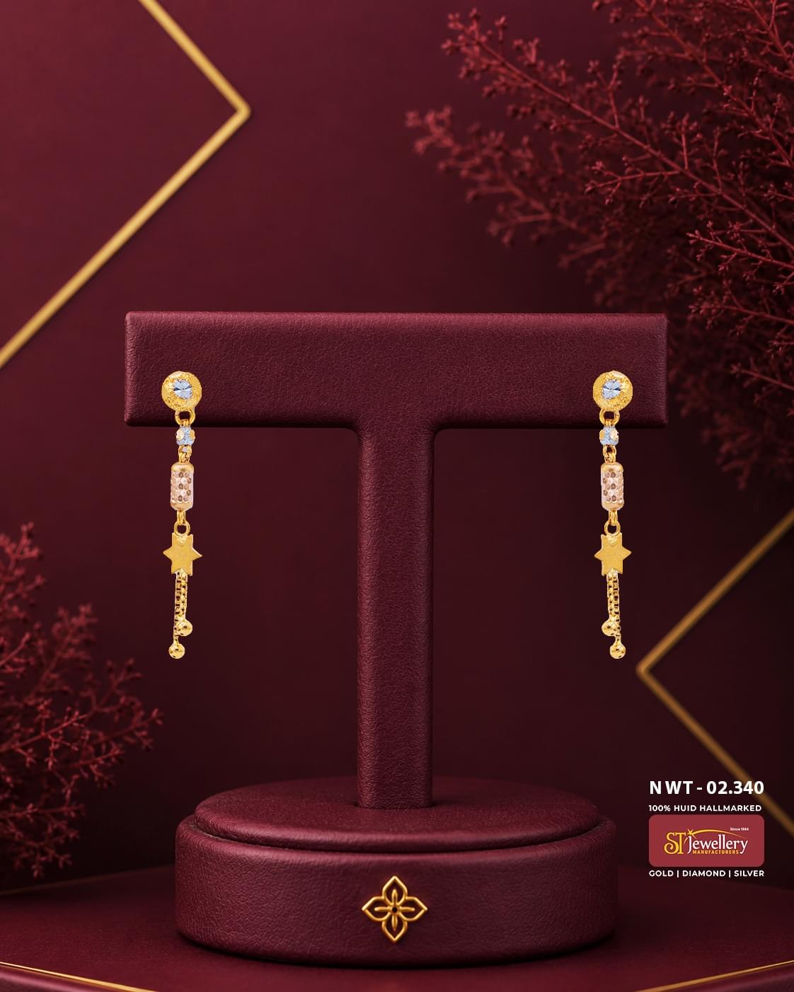 Elegant gold star drop earrings featuring sparkling white stone studs, crystal accents, textured cylindrical beads, and delicate chain tassels for festive and everyday wear.