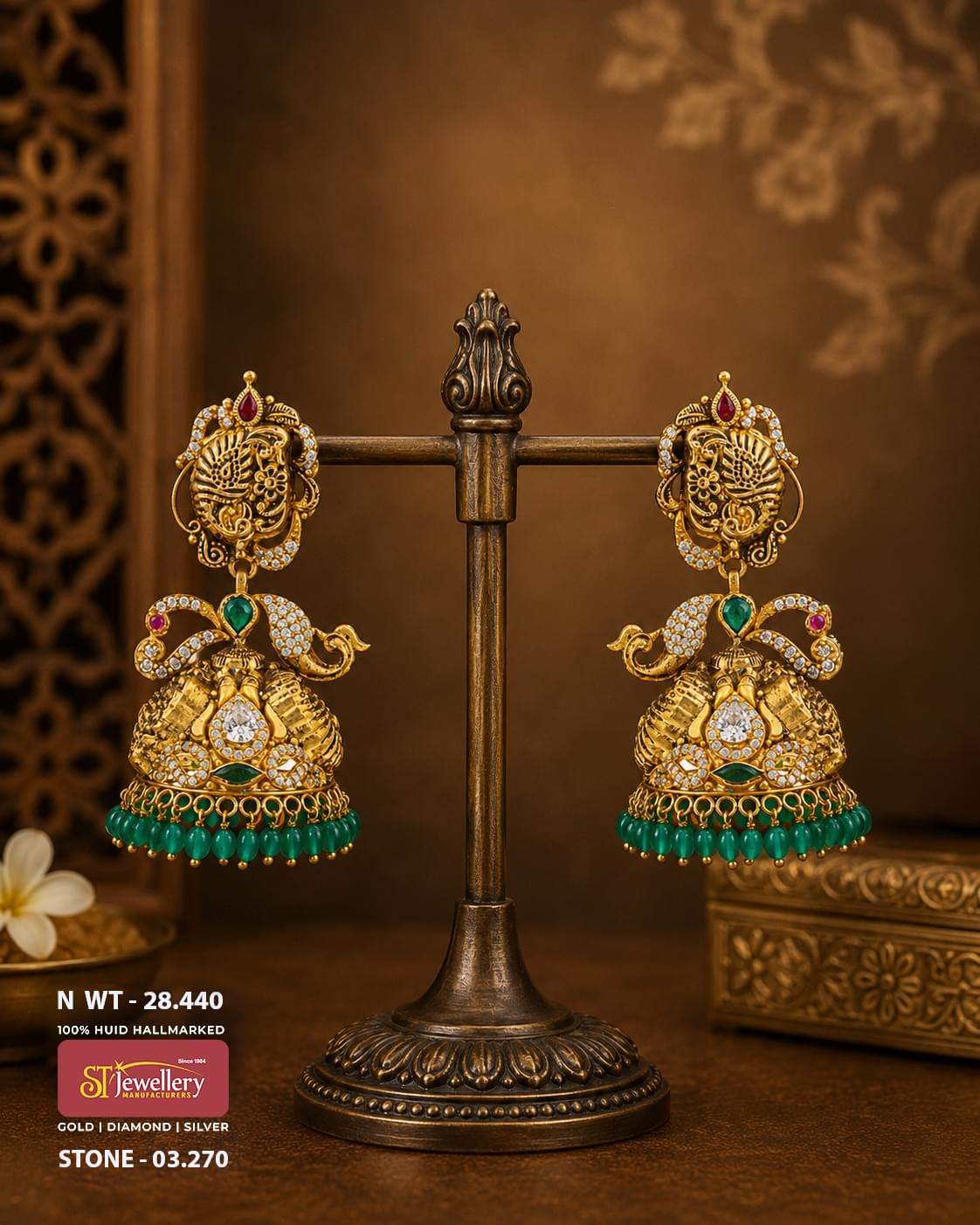 Antique peacock temple gold jhumka earrings featuring emerald green stones, CZ diamond accents, ruby details, and green bead danglers in traditional South Indian bridal jewellery.