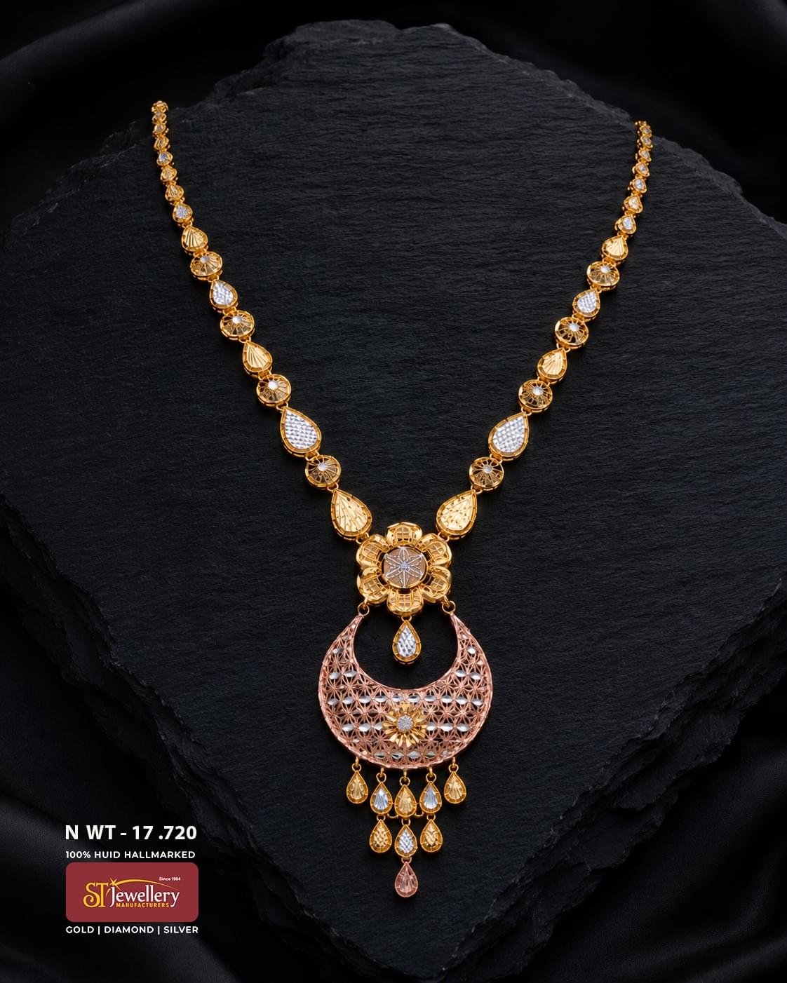 Elegant gold necklace featuring alternating teardrop and circular motifs with intricate detailing, finished with a large crescent-shaped filigree pendant and delicate dangling drops.
