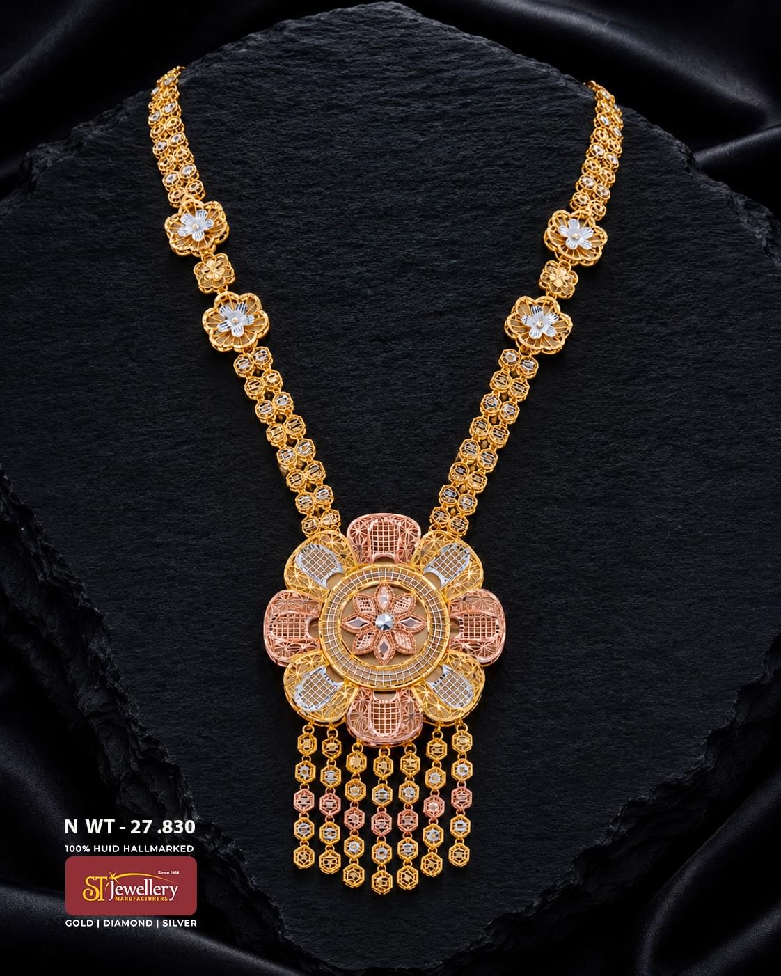 Elegant multitone gold necklace featuring intricate floral motifs in yellow, rose and white tones, finished with a large statement flower pendant and multiple delicate dangling chains.