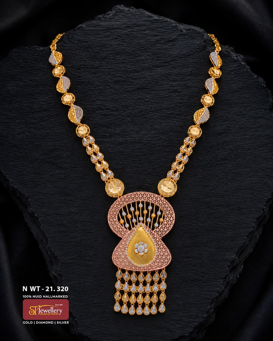 Elegant multitone gold necklace featuring leaf and teardrop motifs with intricate detailing, finished with a large rose-gold filigree pendant, floral centre and cascading teardrop drops.