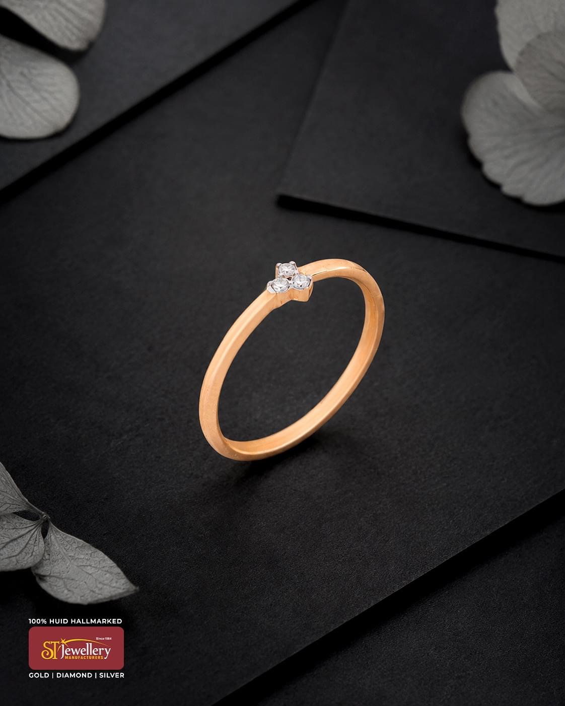 Minimal rose gold ring featuring a delicate three-stone cluster design, displayed on a premium black background.