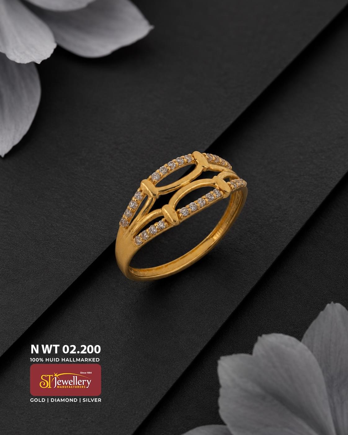 Elegant gold ring featuring a modern layered geometric openwork design with delicate white stone accents, displayed on a premium matte black background.