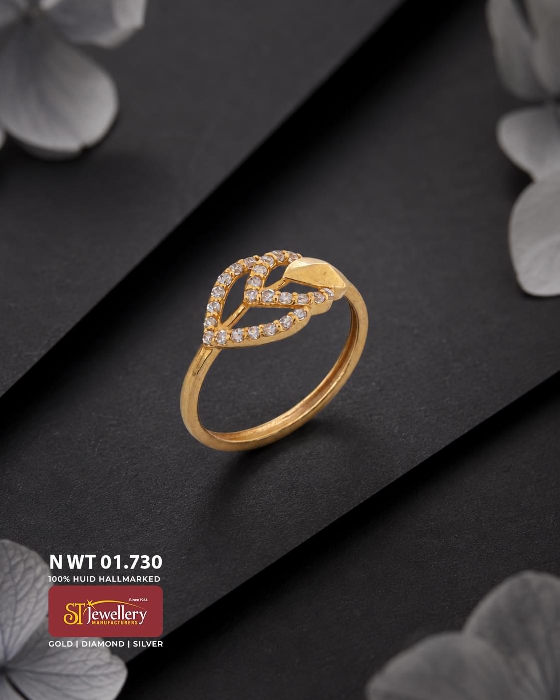 Elegant gold ring featuring a leaf-inspired openwork design with sparkling white stone accents, displayed on a premium matte black background.