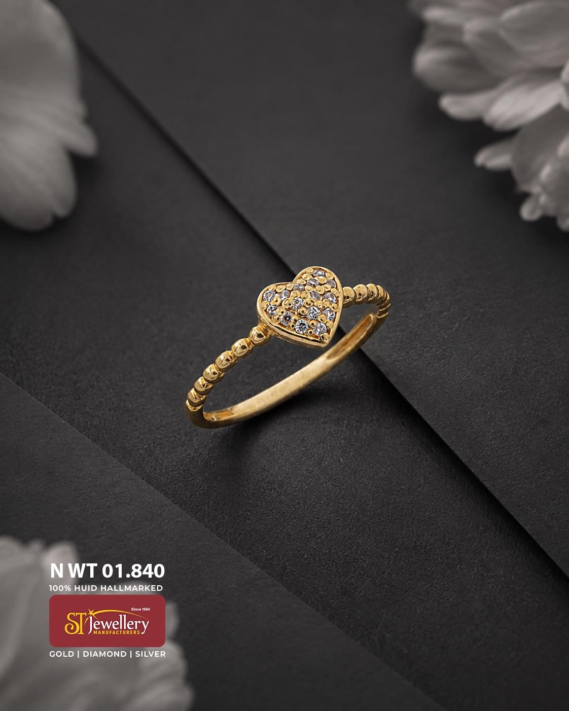 Elegant gold ring featuring a heart-shaped centre with intricate textured detailing and sparkling clear stone accents, finished with a decorative beaded band.
